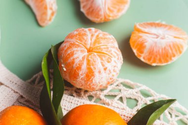 Clementine mandalinaları yeşil yapraklarla kaplıdır.