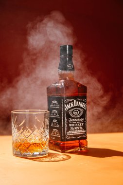 Karanlık bir arka planda bir şişe viski.