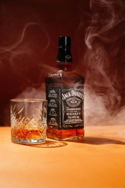 Karanlık bir arka planda bir şişe viski.