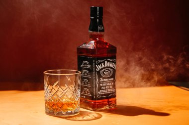 Karanlık bir arka planda bir şişe viski.