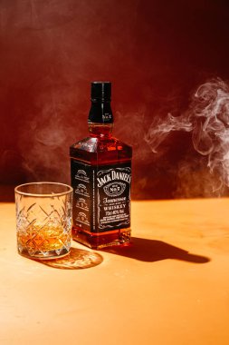 Karanlık bir arka planda bir şişe viski.