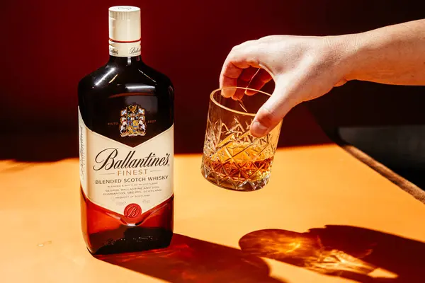 Siyah arka planda bir şişe Ballantine 's Whiskey.