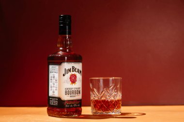 Sarı arka planda bir şişe Jim Beam Whiskey.