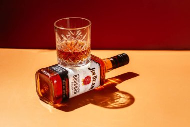 Sarı arka planda bir şişe Jim Beam Whiskey.