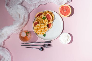 Tabağında greyfurt olan Belçika waffleları. Tatlı.