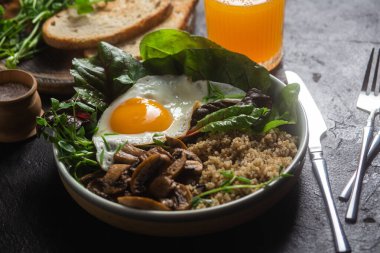 Masada yumurta, mantar ve salata ile kinoa. Kase