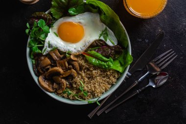 Yağda yumurta, pastırma, domates ve marul tabakta. Kase