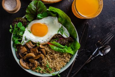 Yağda yumurta, pastırma, domates ve marul tabakta. Kase