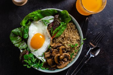Masada yumurta, mantar ve salata ile kinoa. Kase