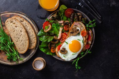 Yağda yumurta, pastırma, domates ve marul tabakta. Kase