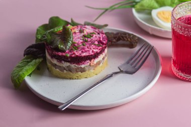 Ringa balıklı salata ve tabakta pancar. Kürk mantonun altında salata.