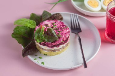 Ringa balıklı salata ve tabakta pancar. Kürk mantonun altında salata.