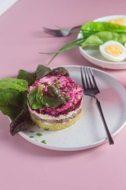 Ringa balıklı salata ve tabakta pancar. Kürk mantonun altında salata.