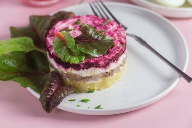 Ringa balıklı salata ve tabakta pancar. Kürk mantonun altında salata.