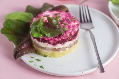 Ringa balıklı salata ve tabakta pancar. Kürk mantonun altında salata.