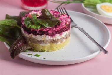 Ringa balıklı salata ve tabakta pancar. Kürk mantonun altında salata.