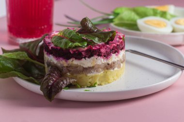 Ringa balıklı salata ve tabakta pancar. Kürk mantonun altında salata.