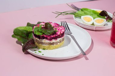 Ringa balıklı salata ve tabakta pancar. Kürk mantonun altında salata.