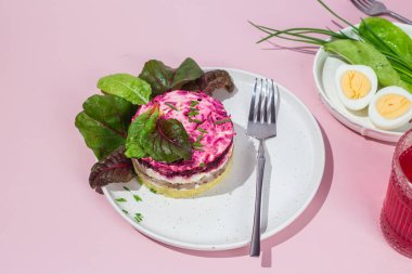 Ringa balıklı salata ve tabakta pancar. Kürk mantonun altında salata.