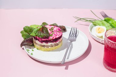 Ringa balıklı salata ve tabakta pancar. Kürk mantonun altında salata.