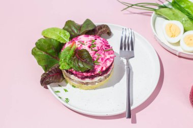 Ringa balıklı salata ve tabakta pancar. Kürk mantonun altında salata.