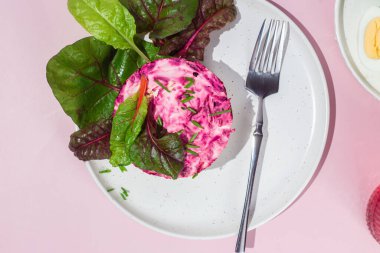 Ringa balıklı salata ve tabakta pancar. Kürk mantonun altında salata.