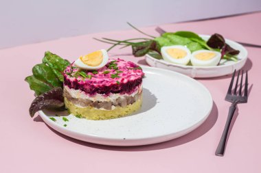 Ringa balıklı salata ve tabakta pancar. Kürk mantonun altında salata.