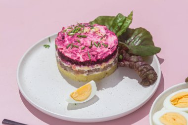 Ringa balıklı salata ve tabakta pancar. Kürk mantonun altında salata.