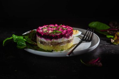 Ringa balıklı salata ve tabakta pancar. Kürk mantonun altında salata.