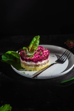 Ringa balıklı salata ve tabakta pancar. Kürk mantonun altında salata.