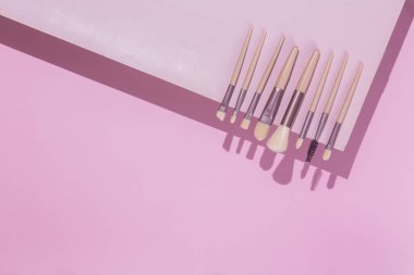 Pembe arka planda makyaj fırçaları. Kozmetik.