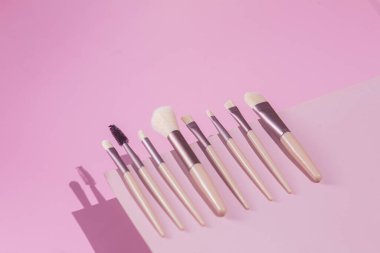 Pembe arka planda makyaj fırçaları. Kozmetik.
