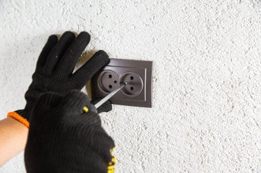 Adam elektrik prizinde vidalanıyor.