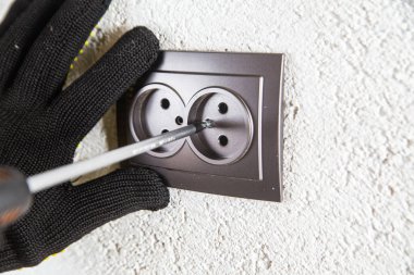 Adam elektrik prizinde vidalanıyor.