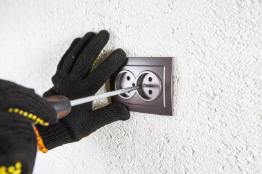 Adam elektrik prizinde vidalanıyor.