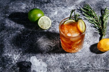 Gri arka planda viski ve limon kokteyli.