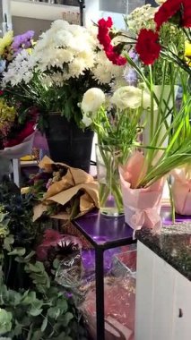 Çiçekçi. Bir dükkanda farklı çiçeklerden buketler. Pencereyi sakla