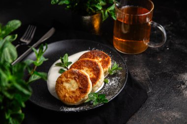 Krem soslu peynirli kekler ve masada siyah bir tabakta nane şekeri. Kahvaltı.