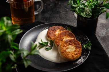 Krem soslu peynirli kekler ve masada siyah bir tabakta nane şekeri. Kahvaltı.
