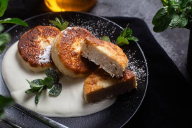 Krem soslu peynirli kekler ve masada siyah bir tabakta nane şekeri. Kahvaltı.