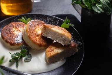 Krem soslu peynirli kekler ve masada siyah bir tabakta nane şekeri. Kahvaltı.