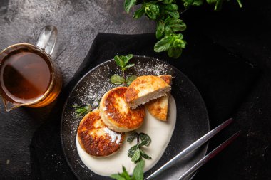 Krem soslu peynirli kekler ve masada siyah bir tabakta nane şekeri. Kahvaltı.