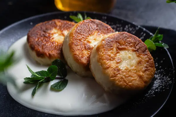 Krem soslu peynirli kekler ve masada siyah bir tabakta nane şekeri. Kahvaltı.