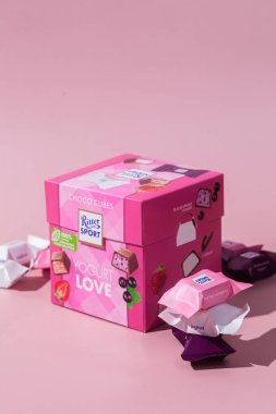 Çikolatalı şekerler Ritter Spor Yoğurt karışımı pembe arka planda. Pankart