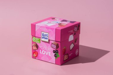 Çikolatalı şekerler Ritter Spor Yoğurt karışımı pembe arka planda. Pankart