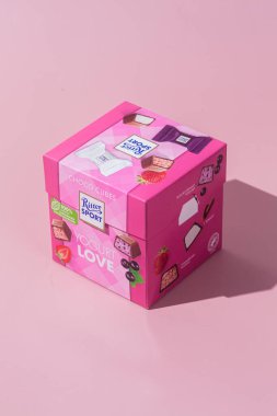 Çikolatalı şekerler Ritter Spor Yoğurt karışımı pembe arka planda. Pankart