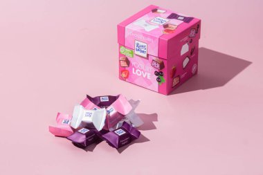 Çikolatalı şekerler Ritter Spor Yoğurt karışımı pembe arka planda. Pankart