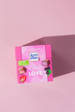 Çikolatalı şekerler Ritter Spor Yoğurt karışımı pembe arka planda. Pankart