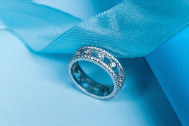 Mavi arka planda Gemstone 'ları olan zarif gümüş bir yüzük.