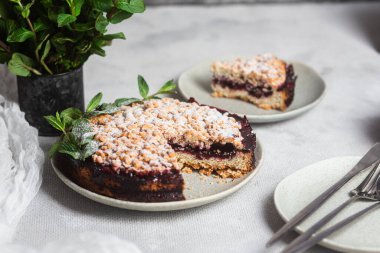 Siyah üzümlü yuvarlak turta ve masada bir tabakta nane şekeri. Tatlı.